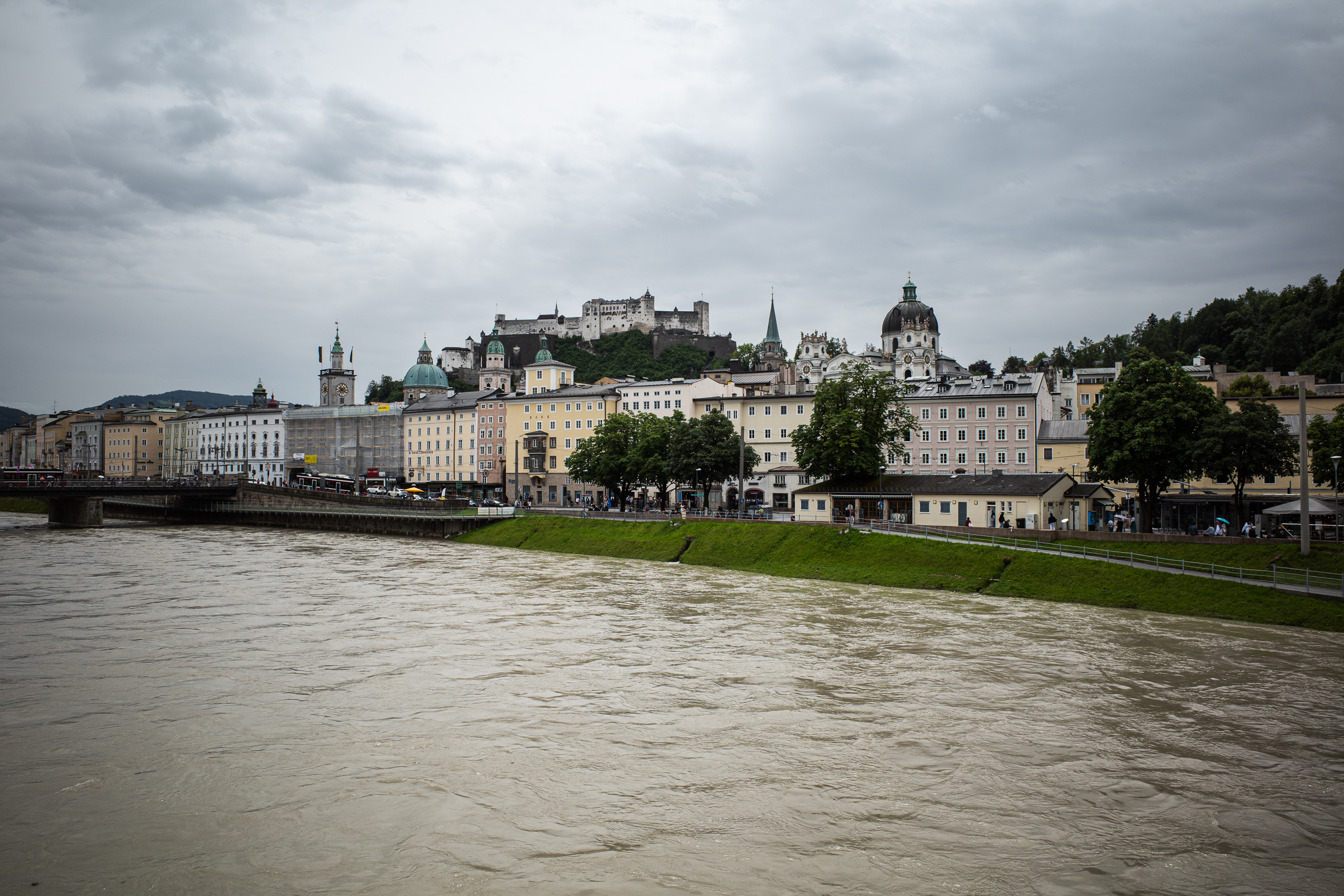 Die Salzach führt Hochwasser, dahinter die Altstadt mit der Festung Hohensalzburg